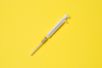 Medical syringe isolated on a yellow background