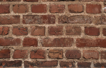 Wall with red bricks of different sizes
