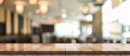 Empty wooden table top with lights bokeh on blur restaurant background
