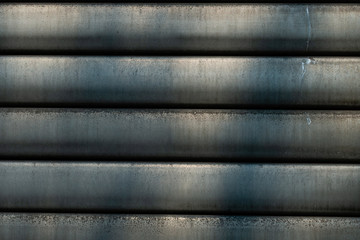 Grey horizontal slats of an industrial roller shutter (abstract detail)