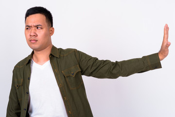 Portrait of stressed young Asian man with stop gesture