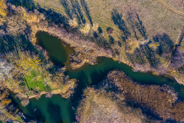 Nature of Russia, Belgorod region, dark river against the background of spring forest, Sunny weather. Sunset light, Aerial View, HEAD OVER SHOT