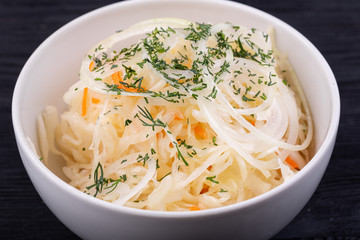 Fermented cabbage with onions and carrots, served with greens