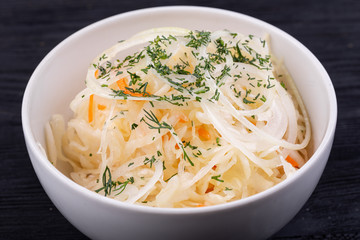 Fermented cabbage with onions and carrots, served with greens