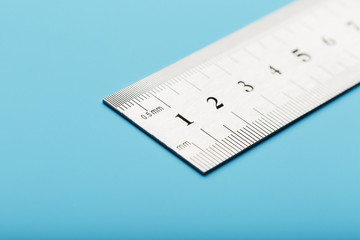 Metal ruler on a blue background close-up with a copy of the space for your text.