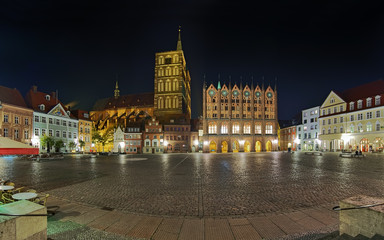 Fototapeta premium Stralsund, Germany. Night panorama of Old Market square with St. Nicholas Church and Town Hall in the Brick Gothic style.