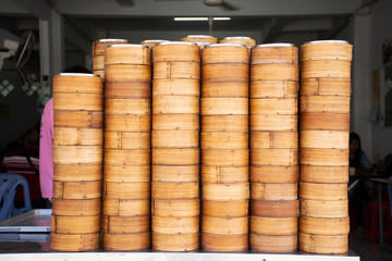 Bamboo basket for steamed dim sum and dumplings and chinese stuffed bun for sale thai people and travelers at local street food restaurant at Betong city in Yala, Thailand