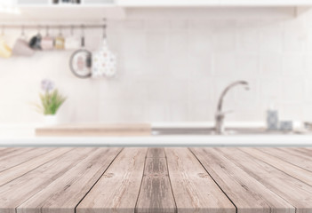 Wooden table with kitchen on the blurred background - modern bright dining room