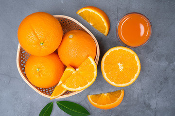 Top view fresh orange fruit sliced with green leaves and orange on bamboo basket on cement table background
