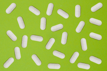 Pattern, many white pills on a green background