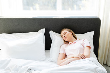Obraz na płótnie Canvas attractive woman sleeping in modern bedroom