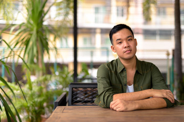 Young Asian man sitting at the coffee shop