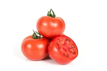 Red fresh tomatoes with sliced one on a white background
