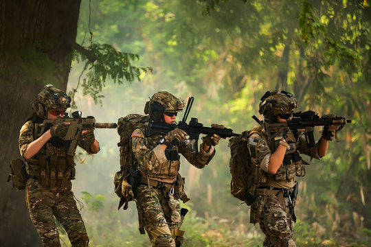 Team of special forces. soldier assault rifle with silencer. sniper in the forest. 