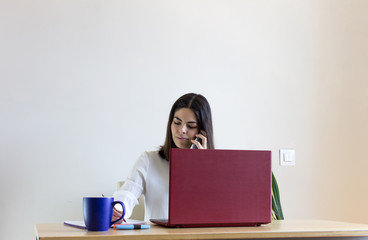Happy casual pretty woman working from home during confinement season, telecommuting.
