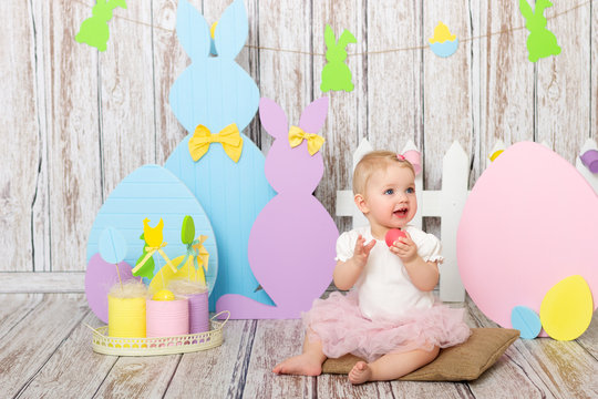 Blond girl playing and smile in easter decorated studio interior.  Family holiday.