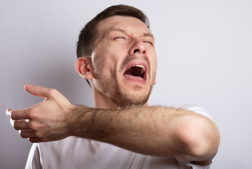 sick man sneezes on his elbow