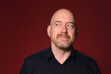 Fototapeta premium man looking to the side on red background, smiling