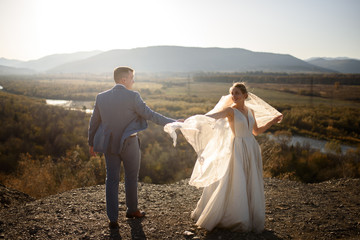 Wedding photo session of the bride and groom in the mountains. Photoshoot at sunset.