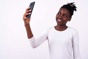 Portrait of happy young beautiful African woman taking selfie