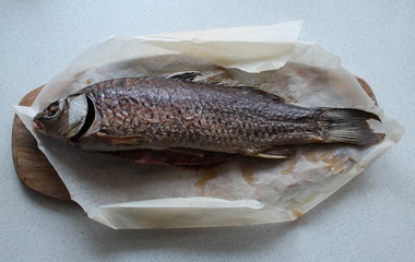 Carp fish cooked in the oven is on a wooden Board.The concept of healthy nutrition.