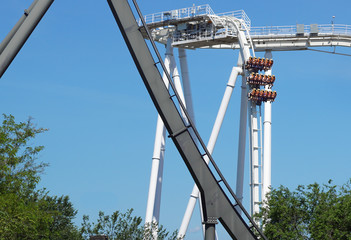 rollercoaster track curving down . Blue sky background