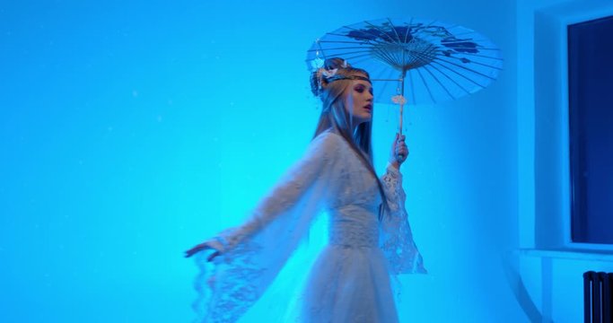 Woman in white traditional japanese dress with an umbrella in hand is dancing 4k