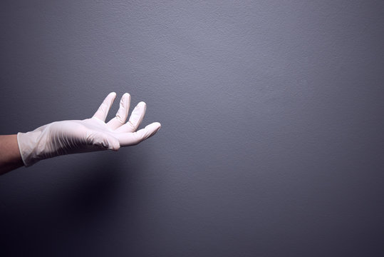 Male Holding Hand Out Wearing White Surgical Glove.