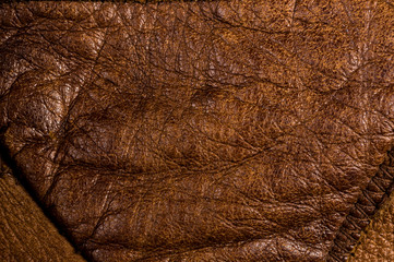 Old vintage genuine soft brown leather texture background, top layer with pores and scratches, macro, close-up