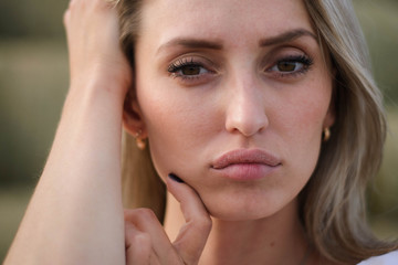 Fototapeta premium portrait of a blonde girl of Slavic origin on a sunny summer day in a field against the sky