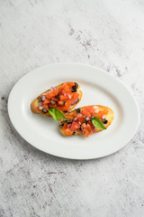 Hot bruschettas with salmon and vegetables on a plate