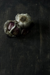 rustic wooden background with two garlic cloves in the upper left corner