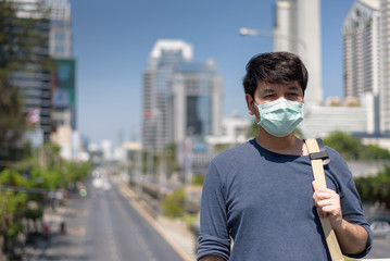 Asian man wear surgical face mask carrying  shoulder travel in the city, coronavirus,covid19