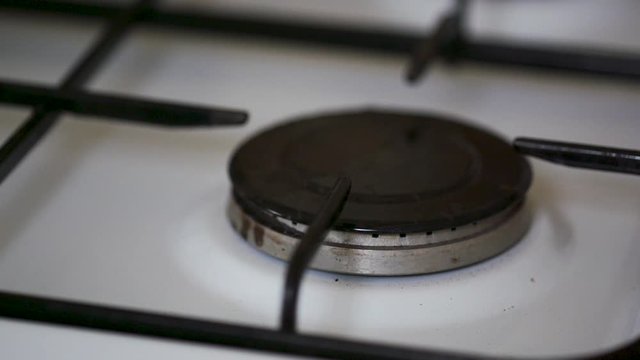 close up of gas stove being lit with pot slow motion