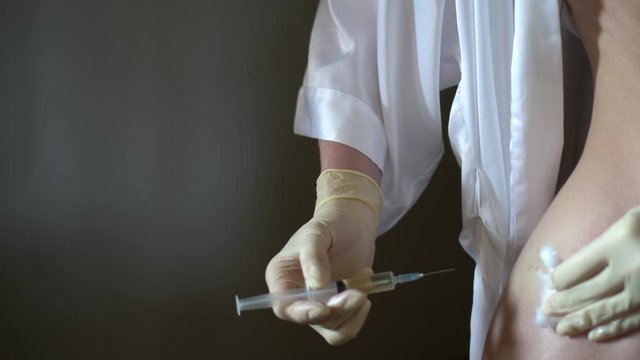 Self-injection of antibiotics. Female preparing needle for injecting her buttocks. Woman injecting buttocks.