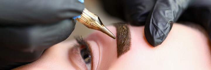 Beauty masters hands do permanent eyebrow makeup - obrazy, fototapety, plakaty