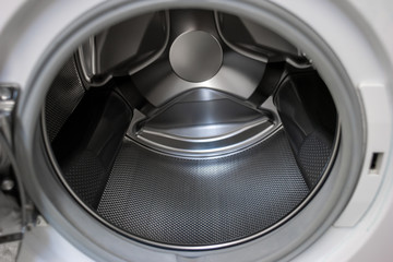 Washing machine open door silver metal empty tumbler close up shot