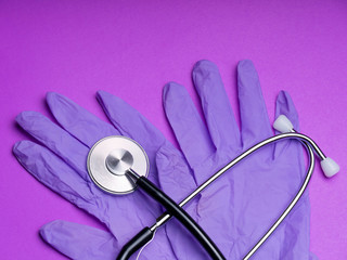 Black stethoscope for doctor diagnostic coronavirus disease, medical tool for health on purple background with copy space. Phonendoscope . stethoscope, masks ,gloves. Medical instruments. 