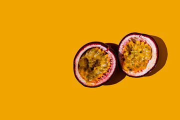 Cut passion fruit on a yellow background.