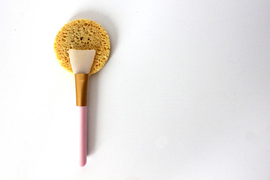 cosmetic items sponge, spatula for mask) on a white background in the left side of the photo top view.