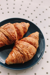 Fresh baked french croissants in blue plate on white background. Breakfast.