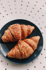 Fresh baked french croissants in blue plate on white background. Breakfast.