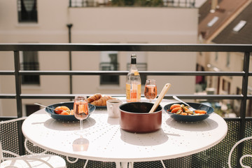 Yummy and healthy breakfast with eggs, tomatoes, avocado, wine, coffee and croissants on the terrace. French breakfast