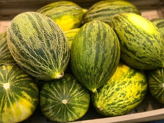fresh green melons (honeydew) in a market
