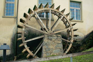 Antique wheel for pumping water. Used as a decor near the building.