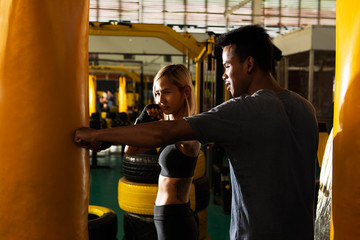 Young asia woman doing kickboxing training with her coach.