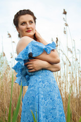 romantic young girl on a background of the sky in a blue dress