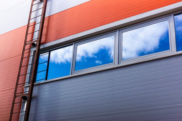 Background wall of industrial building and peaceful sky reflects in windows