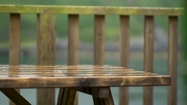 Wooden picnic table with slowmo rain