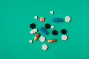 multi colored pills on green background